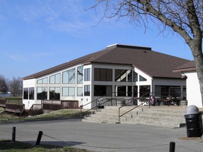 Clubhouse, white modern building with large windows and a brown roof