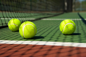 Bright greenish, yellow tennis ball on freshly painted cement court